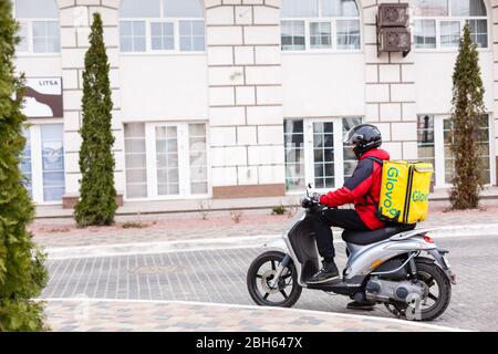 Kiew, UKRAINE - 28. MÄRZ 2020: Сontactless Lieferung von Lebensmitteln an Kunden nach Hause. Delivery Service Worker mit thermischer Rucksack schnell liefern Lebensmittel an Stockfoto