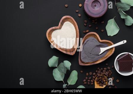 DIY Kosmetik und Spa Konzept. Natürliche Inhaltsstoffe Ton, Kaffee, Eukalyptus und Schokolade für hausgemachte Hautpflegekosmetik auf schwarzem Hintergrund. Stockfoto