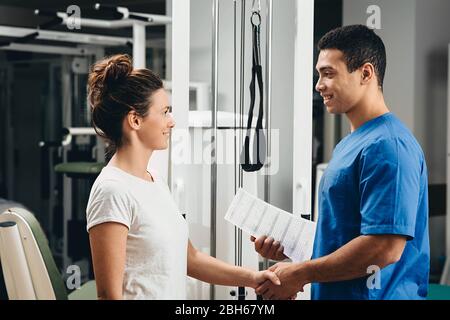 Die Patientin dankt dem Physiotherapeuten für das Training und das gute Ergebnis der Behandlung. Rehabilitationszentrum Stockfoto