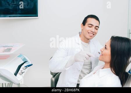 Afro amerikanischen Zahnarzt Untersuchung Zähne zu einer Patientin in der Zahnklinik. Stockfoto