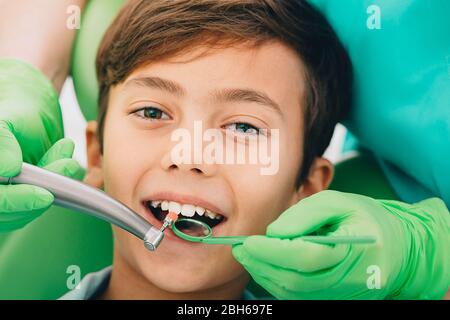 Kleiner netter Junge während Zahnbehandlung. Plaque-Reinigung, Nahaufnahme. Kinderzahnheilkunde Stockfoto