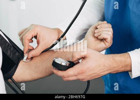 Der Arzt misst den Blutdruck des Patienten, Nahaufnahme. Überprüfen Sie den Blutdruck Stockfoto
