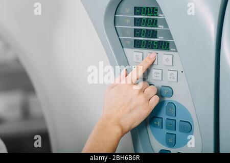 Im Vordergrund richtet der Radiologe die Tomographie-Untersuchung scanner.computer ein, die CAT-Nahaufnahme Stockfoto