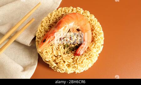 Würzige Instant-Nudelsuppe mit Garnelen. Garnelensuppe, Kochen, Lebensmittel. Roh getrocknet kreisförmige Vermizelli mit würzigen. Asiatische Lebensmittel. Pasta, für die Vorbereitung Stockfoto