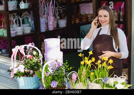 Florist nimmt Telefon bestellen im Blumenladen Stockfoto