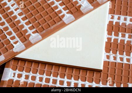 Keramikfliesen aus nächster Nähe. Ein detailreicher Schuss von drei Keramikfliesen. Vorder- und Rückseite von Keramikfliesen für Wände. Baumaterialien. Selektiver Fokus. Stockfoto