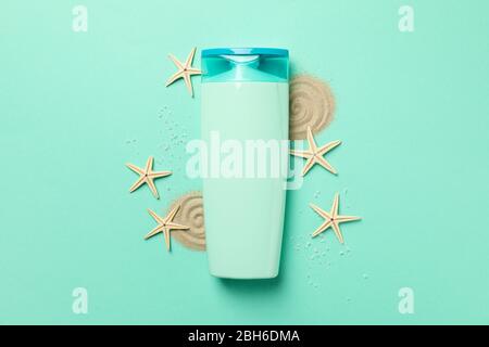 Flasche Shampoo, Seesterne und Sand auf Minzgrund Stockfoto