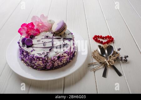 Hausgemachte Heidelbeer-Käsekuchen zum Valentinstag, mit Blumen und Makronen auf weißem Holztisch Hintergrund dekoriert. Draufsicht. Stockfoto