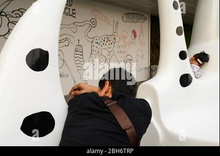 Mann und Frau ruhen auf einer Arty Bank, Bangkok, Thailand Stockfoto