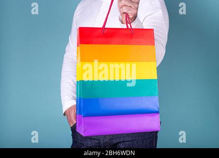 Nahaufnahme eines Mannes mit einer Tasche in den lgtb-Farben auf blauem Hintergrund. Ich akzeptiere lgtb. Shooping-Tag Stockfoto