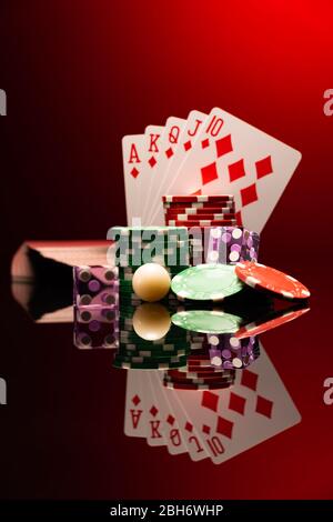 Casino-Set mit Roulette-Kugel, Karten, Würfel und Chips auf Blackjack-Matte Stockfoto