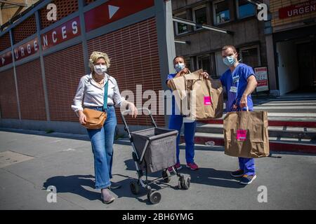 Paris, Frankreich. April 2020. Zwei medizinische Mitarbeiter erhalten während der Sperrung von Marie Chavarot vor dem Cochin-Krankenhaus Lunchboxen, um die Ausbreitung von COVID-19 in Paris, Frankreich, 23. April 2020 zu verhindern. Marie Chavarot ist eine Autodidaktikerin, die vor vier Jahren ihr kulinarisches Labor geschaffen hat. Seit dem 1. April kocht sie vier Tage die Woche für das medizinische Personal des Cochin-Krankenhauses und liefert ihnen Lunchboxen mit kulinarischen Kreationen, um sich auf ihre Weise zu bedanken. Kredit: Aurelien Morissard/Xinhua/Alamy Live News Stockfoto