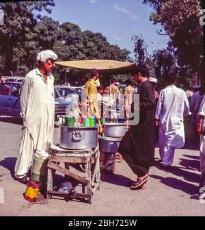Pakistan, Islamabad, Kleinunternehmen, Safthändler mit Einheimischen, die auf dem Juma Bazaar Freitagsmarkt einkaufen, nach dem Freitag-Morgengebet Stockfoto