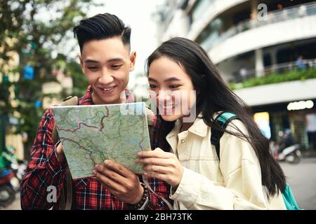 Ein paar Touristen benutzen eine Karte auf Papier auf der Straße Stockfoto