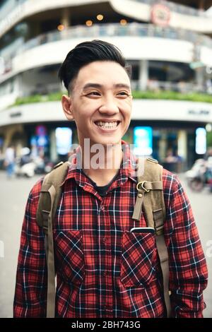 Junge asiatische Mann lächelnd und wegschauen Stockfoto