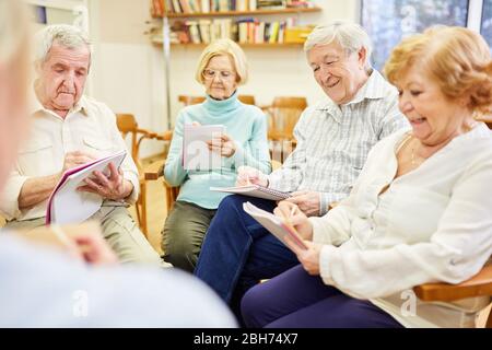 Senioren in der Gruppentherapie Schreiben oder Ausfüllen von Fragebögen Stockfoto