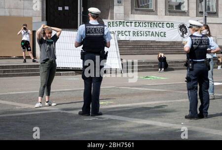 Stuttgart, Deutschland. April 2020. Ein Aktivist spricht mit Polizisten auf dem Marktplatz während einer Aktion der Klimabewegung 'Fridays for Future'. Bundesweit und auch in Baden-Württemberg forderte die Organisation, bemalte Plakate an Fenstern und in den Städten aufzuhängen und setzte damit den Protest unter Einhaltung der Kontaktbeschränkungen fort. Quelle: Marijan Murat/dpa/Alamy Live News Stockfoto