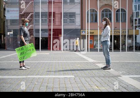 Stuttgart, Deutschland. April 2020. Zwei Aktivisten der Klimabewegung 'Fridays for Future' sprechen bei einer Aktion auf dem Marktplatz miteinander. Bundesweit und auch in Baden-Württemberg forderte die Organisation, bemalte Plakate an Fenstern und in den Städten aufzuhängen und setzte damit den Protest unter Einhaltung der Kontaktbeschränkungen fort. Quelle: Marijan Murat/dpa/Alamy Live News Stockfoto