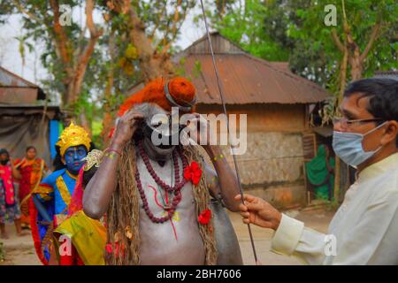AGARTALA,TRIPURA,INDIEN,12-04-2020 : Volkskünstler führen die Rituale von Shiber Gajan durch, indem sie das Gesicht mit Tuch und Maske bedecken, während einer landesweiten, von der Regierung auferlegten Blockierung als vorbeugende Maßnahme gegen die COVID-19, in den Außenbezirken von Agartala, der Hauptstadt des nordöstlichen Bundesstaates Tripura, Indien. FOTO VON ABHISEK SAHA Stockfoto