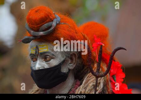 AGARTALA,TRIPURA,INDIEN,12-04-2020 : Volkskünstler führen die Rituale von Shiber Gajan durch, indem sie das Gesicht mit Tuch und Maske bedecken, während einer landesweiten, von der Regierung auferlegten Blockierung als vorbeugende Maßnahme gegen die COVID-19, in den Außenbezirken von Agartala, der Hauptstadt des nordöstlichen Bundesstaates Tripura, Indien. FOTO VON ABHISEK SAHA Stockfoto