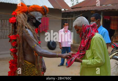 AGARTALA,TRIPURA,INDIEN,12-04-2020 : Volkskünstler führen die Rituale von Shiber Gajan durch, indem sie das Gesicht mit Tuch und Maske bedecken, während einer landesweiten, von der Regierung auferlegten Blockierung als vorbeugende Maßnahme gegen die COVID-19, in den Außenbezirken von Agartala, der Hauptstadt des nordöstlichen Bundesstaates Tripura, Indien. FOTO VON ABHISEK SAHA Stockfoto