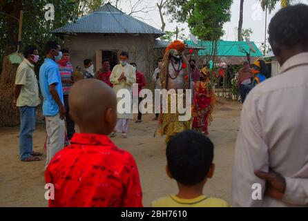 AGARTALA,TRIPURA,INDIEN,12-04-2020 : Volkskünstler führen die Rituale von Shiber Gajan durch, indem sie das Gesicht mit Tuch und Maske bedecken, während einer landesweiten, von der Regierung auferlegten Blockierung als vorbeugende Maßnahme gegen die COVID-19, in den Außenbezirken von Agartala, der Hauptstadt des nordöstlichen Bundesstaates Tripura, Indien. FOTO VON ABHISEK SAHA Stockfoto