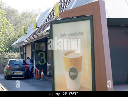 Leicester, Leicestershire, Großbritannien. April 2020. Eine Frau, die in persönliche Schutzausrüstung gekleidet ist, führt während der Sperrung der Coronavirus-Pandemie bei einer McDonaldÕs-Durchfahrt einen Covid-19-Test an einem Schlüsselarbeiter durch. Credit Darren Staples/Alamy Live News. Stockfoto