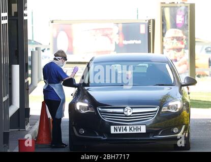 Leicester, Leicestershire, Großbritannien. April 2020. Eine Frau, die in persönliche Schutzausrüstung gekleidet ist, führt während der Sperrung der Coronavirus-Pandemie bei einer McDonaldÕs-Durchfahrt einen Covid-19-Test an einem Schlüsselarbeiter durch. Credit Darren Staples/Alamy Live News. Stockfoto