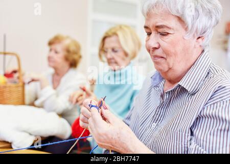 Ältere Frau Häkeln in einem handwerklichen Kurs als Hobby oder Ergotherapie Stockfoto