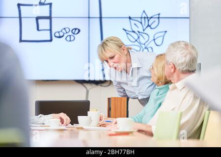 Senioren und Dozent in einem Seminar für Erwachsenenbildung in der VHS Stockfoto