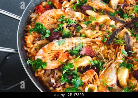 Paella mit Meeresfrüchten, Garnelen und arborio-Reis, garniert mit Petersilie Stockfoto