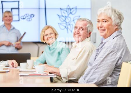 Lächelnde Senioren in einem VHS-Seminar über Heilpflanzen und Gesundheit Stockfoto