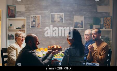 Aufgeregt junge Frau, als ihr Mann mit leckeren Kuchen an ihrem Geburtstag kommt. Zeitlupe aufgenommen Stockfoto