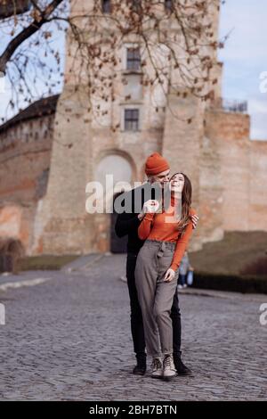 Junge glückliche Paar auf alten Stadthintergrund. Ein Liebespaar, das einen Spaziergang im Innenhof der Altstadt genießt. Vor dem Hintergrund rote Ziegelwände Stockfoto