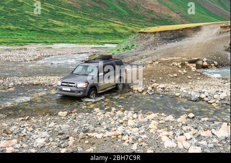 Off Road Fahrzeug Überqueren einer Mountain River bei Tosor Pass, Naryn region, Kirgisistan, Zentralasien Stockfoto