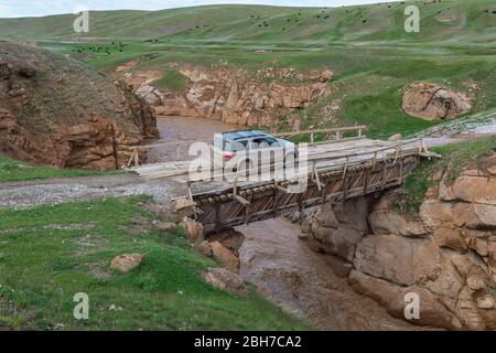 Allradantrieb auto Überqueren einer Holzbrücke über eine wilde Schlucht, Provinz Naryn, Kirgisistan Stockfoto