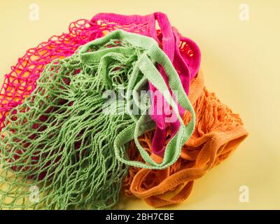 Wiederverwendbare Baumwollmaschentaschen auf gelbem Hintergrund. Stockfoto