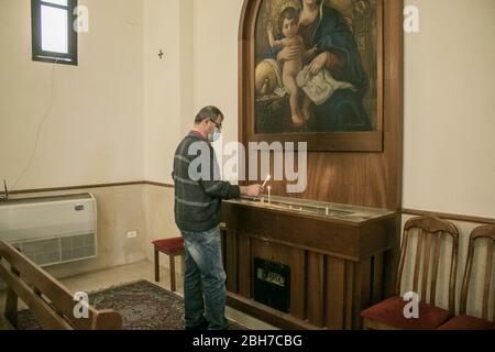Beirut, Libanon. 24. April 2020. Ein Mann zündet am Tag der Gedenkfeier zum Völkermord an den Armeniern in der Kirche von Vartanants eine Kerze an, um an die 1.5 Millionen ethnischen Armenier zu erinnern, die 1915 in der Türkei zur Zeit des Osmanischen Reiches ermordet wurden. Die Türkei lehnt jede Verantwortung ab und hat immer bestritten, dass die Morde Völkermord waren. Kredit: amer Ghazzal/Alamy Live News Stockfoto