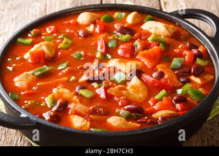 Mexikanisches Huhn mit roten Bohnen in würziger Chilisauce Nahaufnahme in einer Pfanne auf dem Tisch. Horizontal Stockfoto