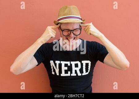 Porträt von gestressten jungen Nerd Tourist Mann mit Kopfschmerzen Stockfoto