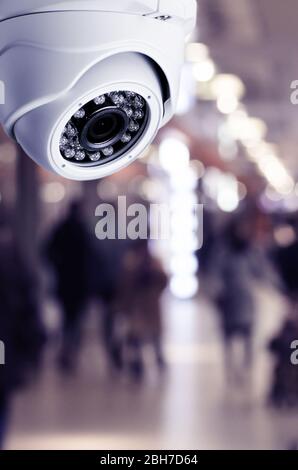 CCTV-Kamera-Sicherheitssystem an der Decke eines Einkaufszentrums verschwommener Hintergrund. Mock-up mit getönten Bildern Stockfoto