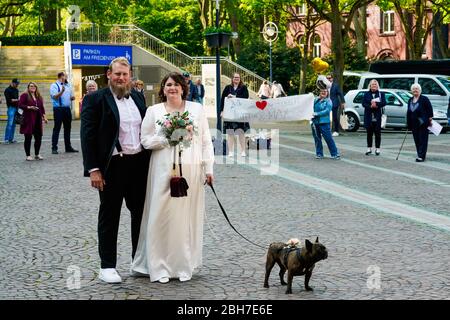 Dortmund, 24. April 2020: Hochzeit in Corona Times. Ein Paar heiratete am 24. April. Vor dem Standesamt gratulierten Familienangehörige und Freunde ihnen im angemessenen Sicherheitsabstand. Stockfoto