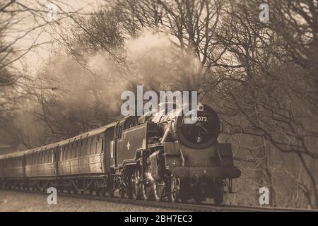 Niedrige Winkel, Sepia Ansicht von Vintage UK Dampfzug auf Bahnstrecke in Worcestershire ländlichen Landschaft, Severn Valley Railway Heritage Line, Großbritannien Stockfoto