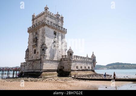 Torre de Belem, Lissabon, Portugal. Das beliebte Wahrzeichen Lissabons, der Belem Tower am Tejo, mit einer Reihe von Touristen, die darauf warten, in die Stadt einzutreten. Stockfoto