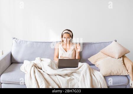 Frau zu Hause mit Videoanruf in Laptop. Vorderansicht einer Frau im Innenraum. Stockfoto