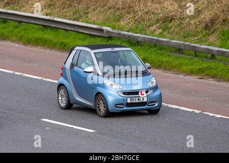 2011 blau silber Smart fortwo Passion MHD Auto; Fahrschüler Autobahntraining, Fahrschüler, unter Anleitung, Fahrschule, Fahrer, Autobahnfahrunterricht, zugelassener Fahrlehrer, beaufsichtigtes Fahrverhalten, Instruktor; Kfz-Verkehrsschilder L auf sich bewegenden Fahrzeugen, Fahren von Fahrzeugen auf britischen Straßen, Motoren, Fahren auf der Autobahn M6 Stockfoto