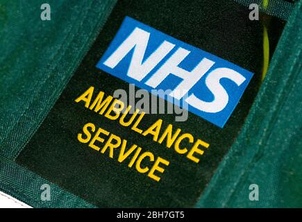 Nahaufnahme, schräge Ansicht eines britischen Sanitäter Abzeichen auf Uniform Jacke mit NHS RETTUNGSDIENST. Stockfoto