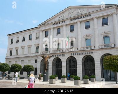 Bergamo, Italien - 06. August 2019: Menschen, die vor einem großen Bankgebäude spazieren Stockfoto