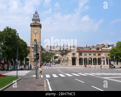 Bergamo, Italien - 06. August 2019: Menschen, die auf den Straßen im unteren Teil der Stadt Bergamo mit Blick auf die befestigte Oberstadt im Hinterland spazieren Stockfoto