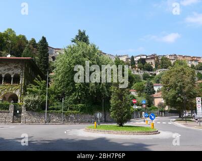 Bergamo, Italien - 06. August 2019: Ein Kreisverkehr im unteren Teil der Stadt Bergamo mit Blick auf die befestigte Oberstadt im Hintergrund Stockfoto